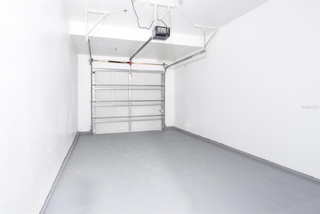 garage with baseboards and a garage door opener