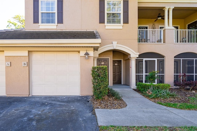 entrance to property with driveway, an attached garage, and stucco siding