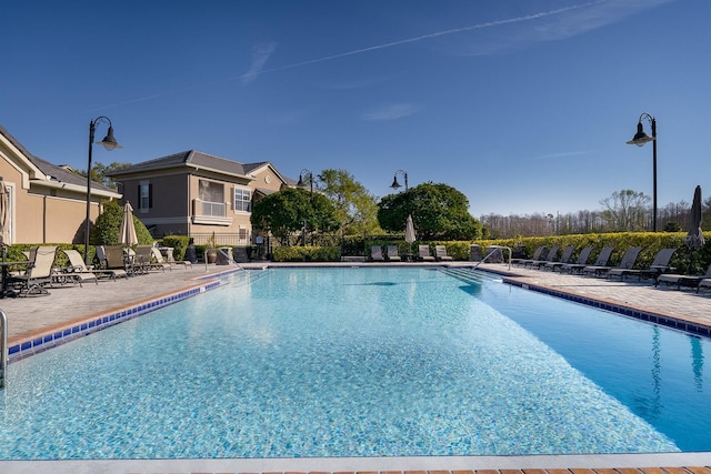 pool featuring fence and a patio