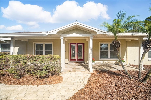 entrance to property featuring french doors and stucco siding