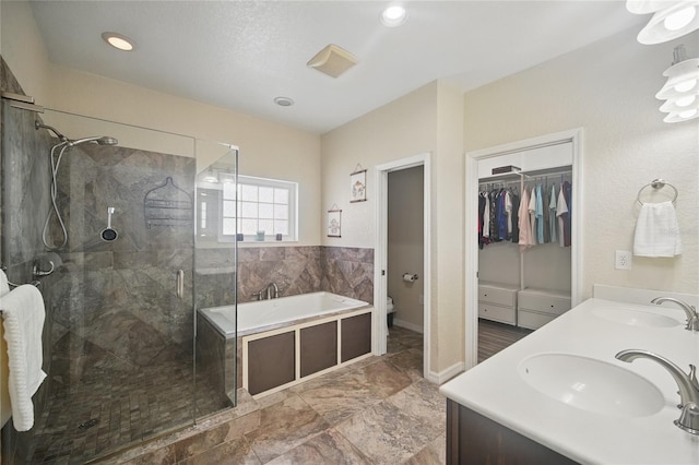 bathroom with toilet, a shower stall, a sink, and a bath