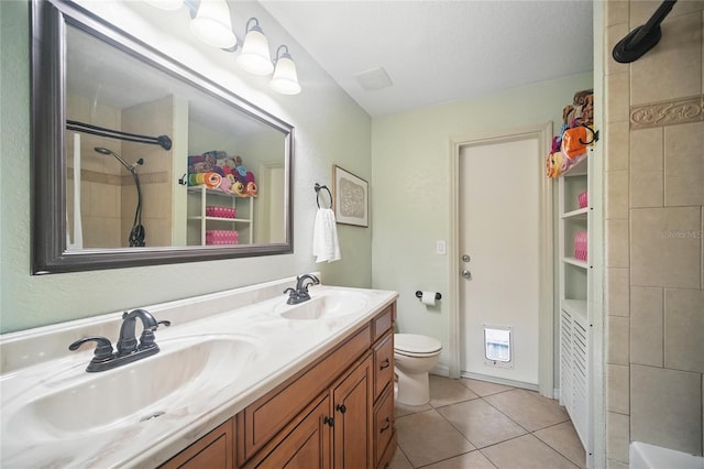 full bath featuring toilet, tile patterned flooring, double vanity, and a sink