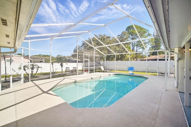 view of swimming pool featuring a fenced in pool, glass enclosure, a patio area, and a fenced backyard