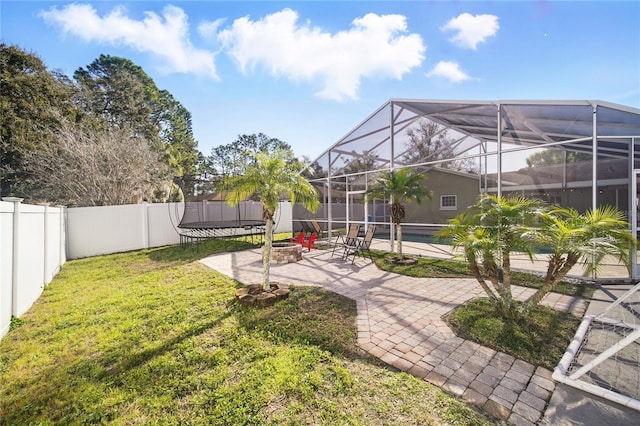 view of yard featuring a fenced backyard, a lanai, a fenced in pool, a trampoline, and a patio area