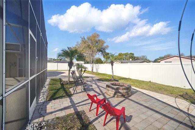 view of patio / terrace featuring a lanai, a fenced backyard, and a fire pit