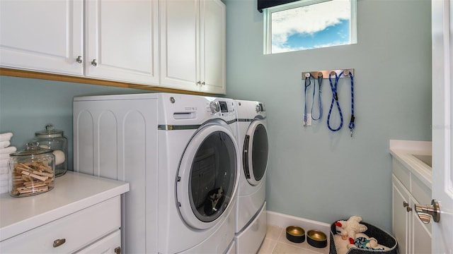 washroom with cabinet space, tile patterned flooring, baseboards, and washer and dryer