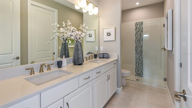 full bath with tile patterned flooring, a sink, toilet, and a shower stall