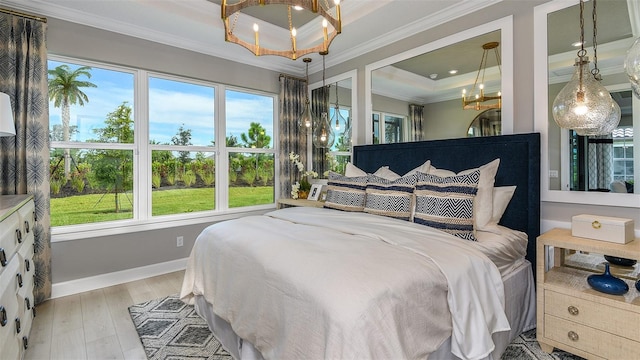 bedroom with light wood finished floors, ornamental molding, multiple windows, and an inviting chandelier