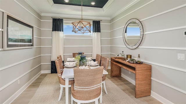 dining space featuring a tray ceiling, a notable chandelier, crown molding, recessed lighting, and wood finished floors