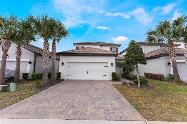 view of front facade with a garage, decorative driveway, and stucco siding