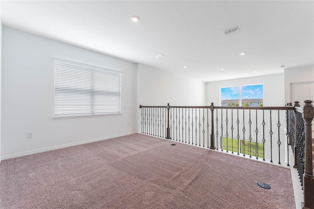 spare room with carpet floors, baseboards, visible vents, and recessed lighting