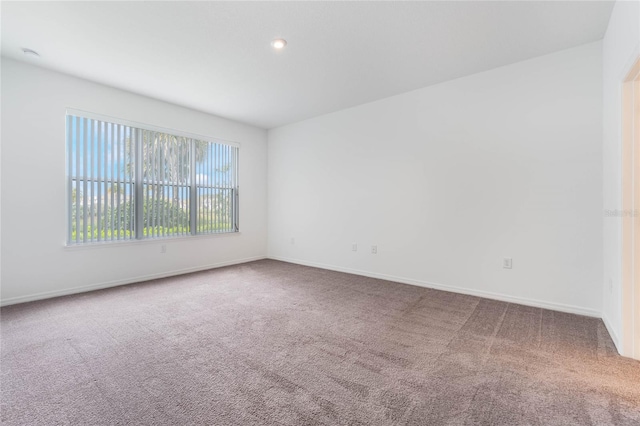 carpeted spare room featuring recessed lighting and baseboards