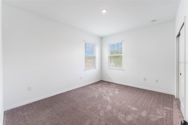 carpeted empty room with baseboards