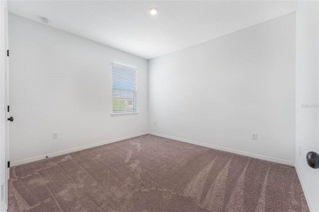 carpeted spare room with baseboards