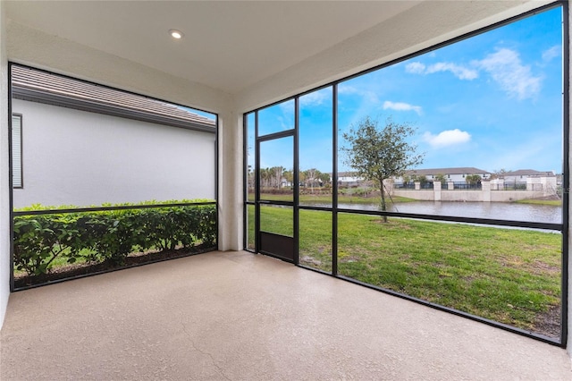 unfurnished sunroom featuring a water view