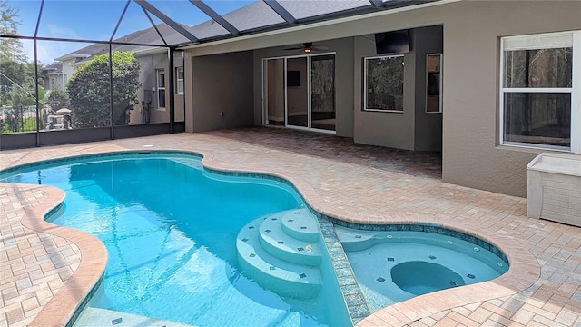 outdoor pool with glass enclosure, a hot tub, and a patio