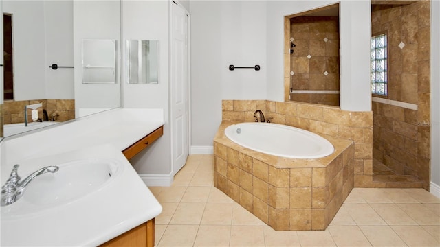 bathroom with tile patterned floors, a bath, and vanity