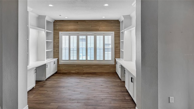 mudroom featuring built in shelves, recessed lighting, wooden walls, dark wood-style flooring, and a textured wall