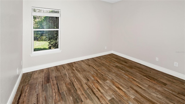 unfurnished room featuring baseboards and wood finished floors