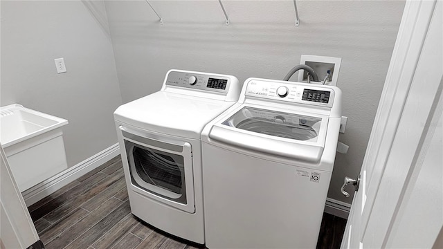 clothes washing area with wood tiled floor, baseboards, separate washer and dryer, and laundry area