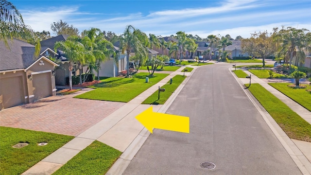 surrounding community featuring decorative driveway, a residential view, and a lawn