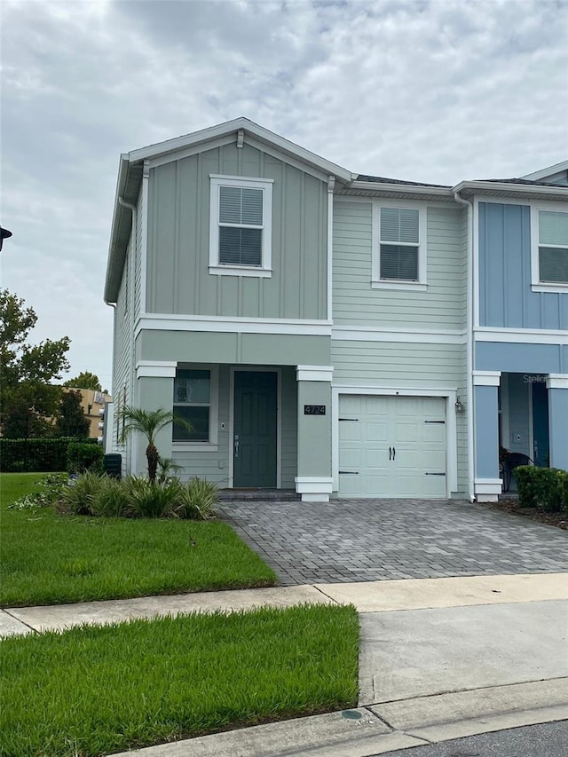 view of front of property with decorative driveway, a garage, and board and batten siding