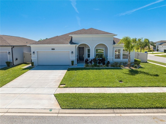 mediterranean / spanish home with a garage, concrete driveway, a gate, a front lawn, and stucco siding