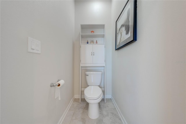 bathroom with tile patterned flooring, baseboards, and toilet