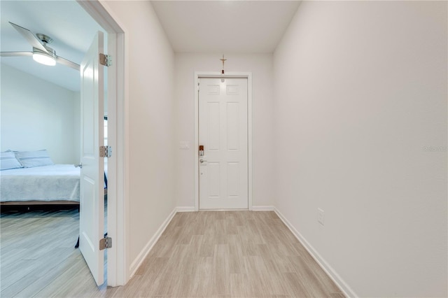 hall featuring light wood-style floors and baseboards