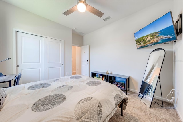 carpeted bedroom with a ceiling fan, a closet, visible vents, and baseboards