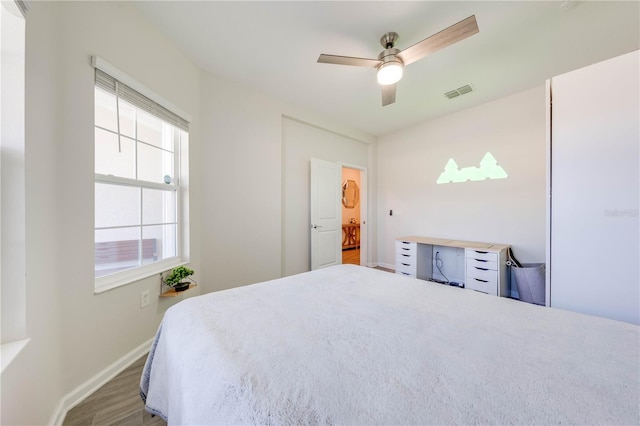 bedroom featuring baseboards, visible vents, a ceiling fan, and wood finished floors