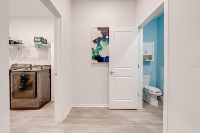 corridor featuring baseboards and separate washer and dryer