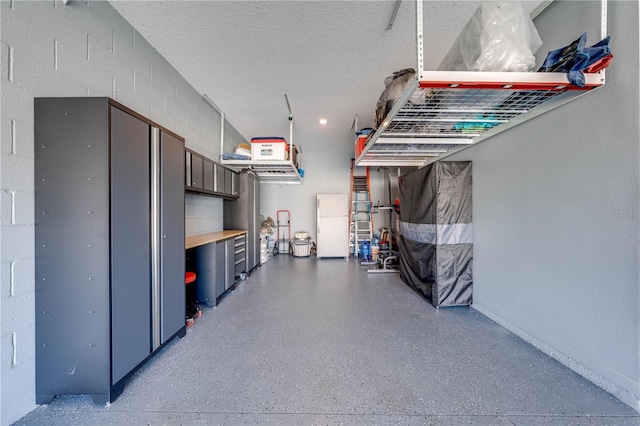 garage with freestanding refrigerator and concrete block wall