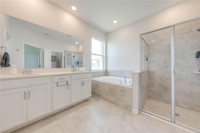 bathroom with a garden tub, a sink, a shower stall, and double vanity