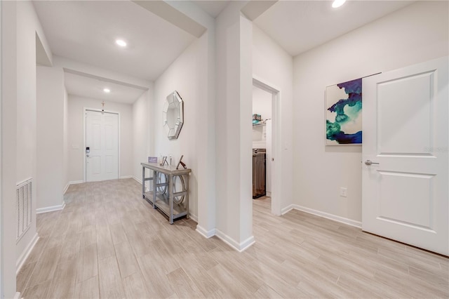 corridor with baseboards, light wood-type flooring, visible vents, and recessed lighting