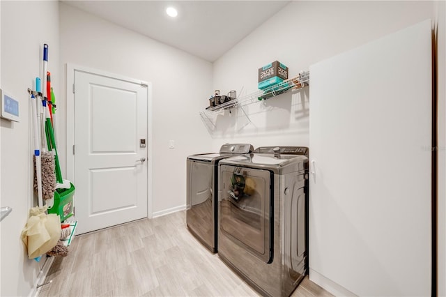 laundry area with baseboards, laundry area, independent washer and dryer, and light wood-style floors