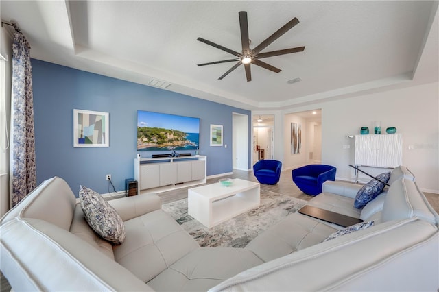 living area with visible vents and a tray ceiling