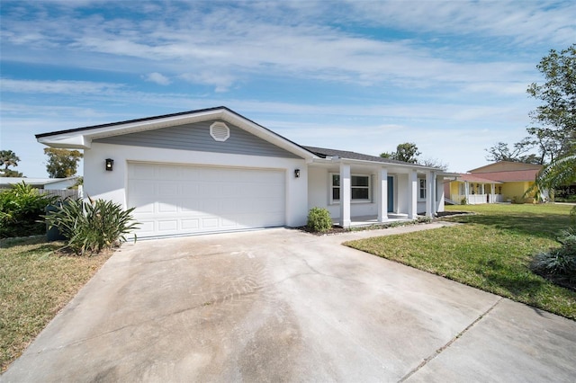 single story home with an attached garage, a front lawn, concrete driveway, and stucco siding