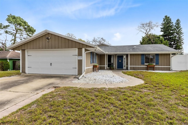 ranch-style home with a front lawn, concrete driveway, and an attached garage