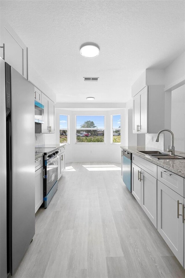 4717 Shad Dr, Sebring, FL 33870 - kitchen featuring appliances with stainless steel finishes, light wood-type flooring, visible vents, and a sink
