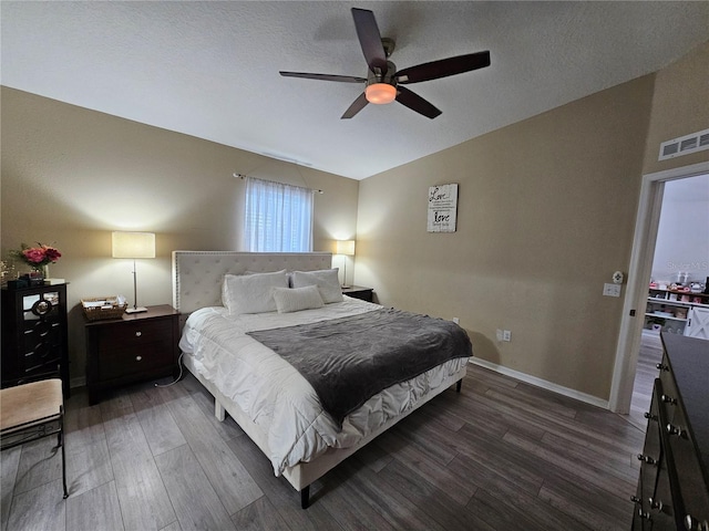 bedroom featuring visible vents, lofted ceiling, ceiling fan, wood finished floors, and a textured ceiling