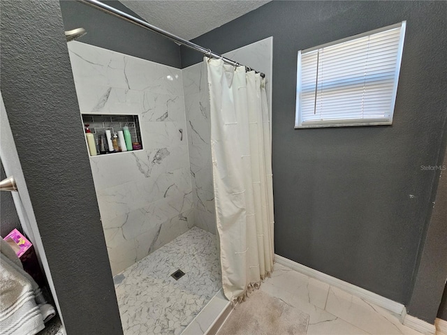 bathroom with curtained shower, marble finish floor, a textured ceiling, and baseboards