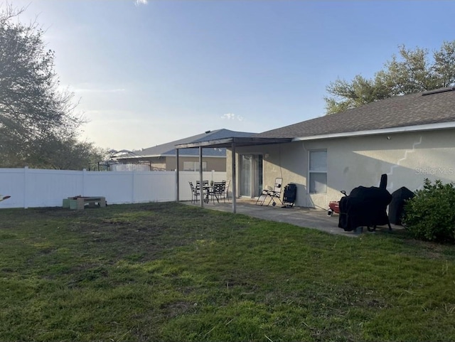 back of property with a patio area, a fenced backyard, a lawn, and stucco siding