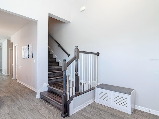 staircase with wood finished floors and baseboards