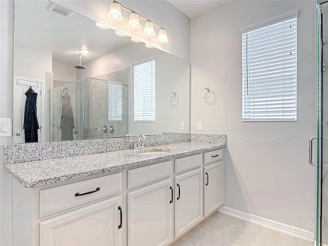 full bath with a stall shower, a healthy amount of sunlight, visible vents, and vanity