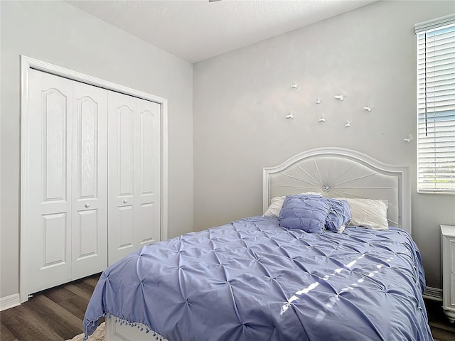 bedroom with dark wood-style floors, a closet, and a textured ceiling