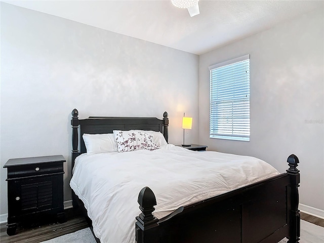 bedroom featuring baseboards and wood finished floors