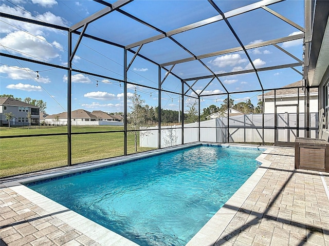 view of swimming pool featuring glass enclosure and a yard