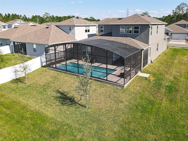 back of house with a lanai, a residential view, a lawn, and stucco siding