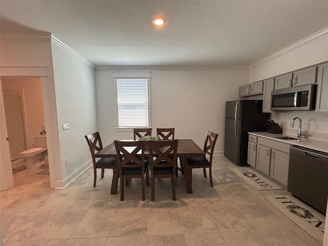 dining room with crown molding, baseboards, and a textured ceiling